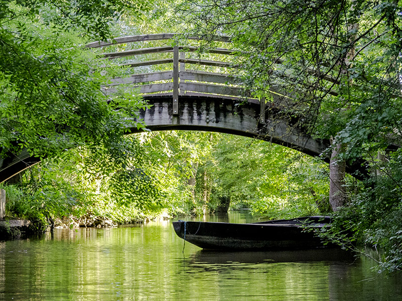 Barque amarrée sous un pont de bois dans la Venise verte